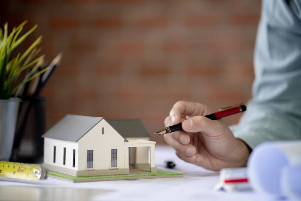 istock Architect Design Concept, engineer holding pen work on Blueprint Construction drawing On the desk in the office, Vintage backgroung brick.Selective Focus at house model 1421256024