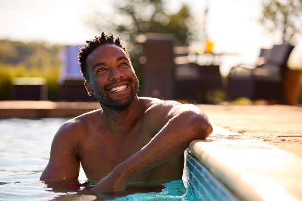 istock Smiling Man On Summer Holiday Relaxing In Swimming Pool 1421256057