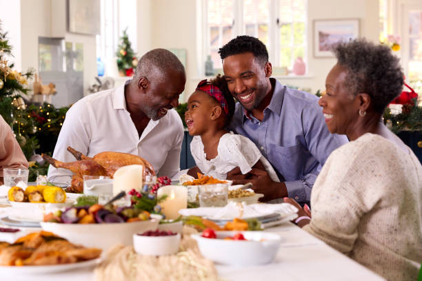 familia multigeneracional celebrando la navidad en casa con el abuelo sirviendo pavo - cena fotografías e imágenes de stock