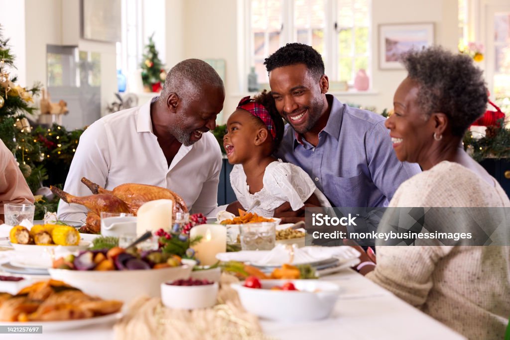 Multi-Generation Family Celebrating Christmas At Home With Grandfather Serving Turkey Family Stock Photo