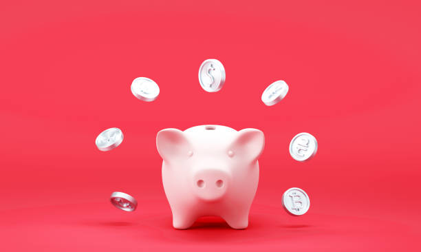 istock Piggy bank with falling dollar coins on red background 1421258104