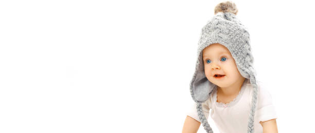 Happy cute little baby wearing gray knitted hat isolated on white background, banner blank copy space for advertising text stock photo