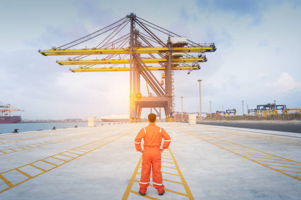 Seaport workers are working at waterfront. Logistics, import, export and transportation concept.