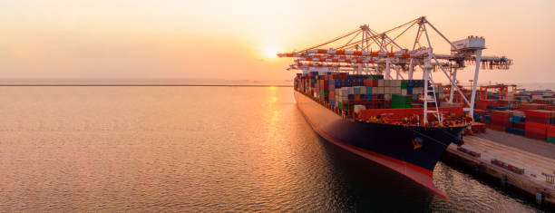 istock crane loading cargo container to container ship in the international terminal yard port  concept freight shipping by ship at sunrise . 1421265237