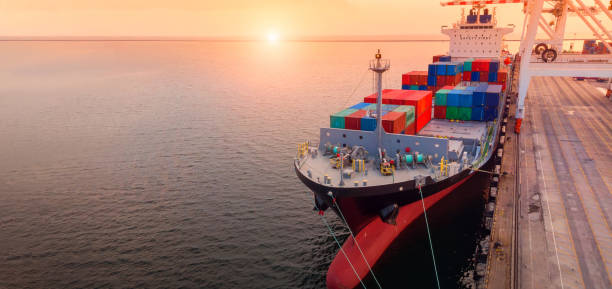 istock crane loanding cargo container to container ship in the international terminal yard port  concept freight shipping by ship at sunrise . 1421266037