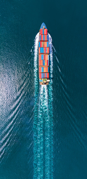 Vista de retrato aéreo de buque de carga inteligente con estela en el buque marítimo oceánico que transporta contenedores desde el depósito de contenedores personalizado ir al concepto de envío de carga oceánica por servicio de barco. photo