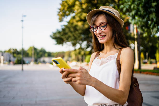 istock Smiling young woman using mobile phone 1421269016