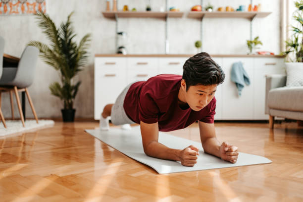 istock Young Man Doing The Plank At Home 1421270403