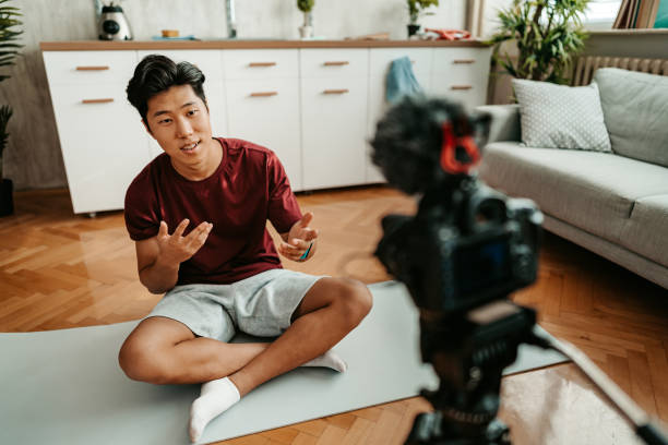 istock Young Man Filming A Vlog On Exercising At Home 1421271134