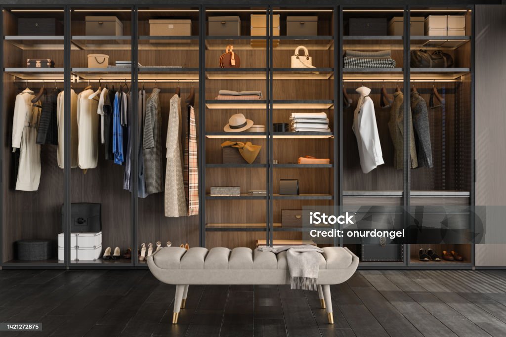 Close-up View Of Walk-in Closet Bench And Wardrobe With Clothes, Boxes, Bags And Shoes Closet Stock Photo