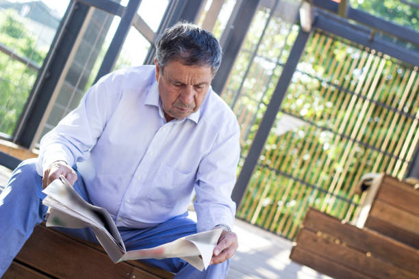 istock Elderly man reading a newspaper outdoors 1421272903
