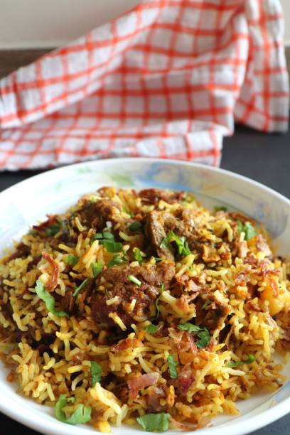 istock Mutton Biryani or Lamb Pulao. Garnished with fried onion & chopped coriander. Biryani is a famous Spicy non vegetarian dish of India. Goat meat cooked along with Basmati rice & spices. 1421273662