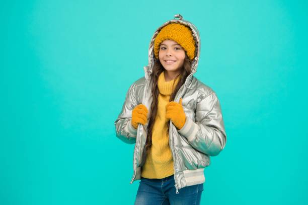 happy kid in silberner pufferjacke und strickwaren werden im winter warm für aktivitäten im urlaub, wintermode - jacket child clothing fashion stock-fotos und bilder