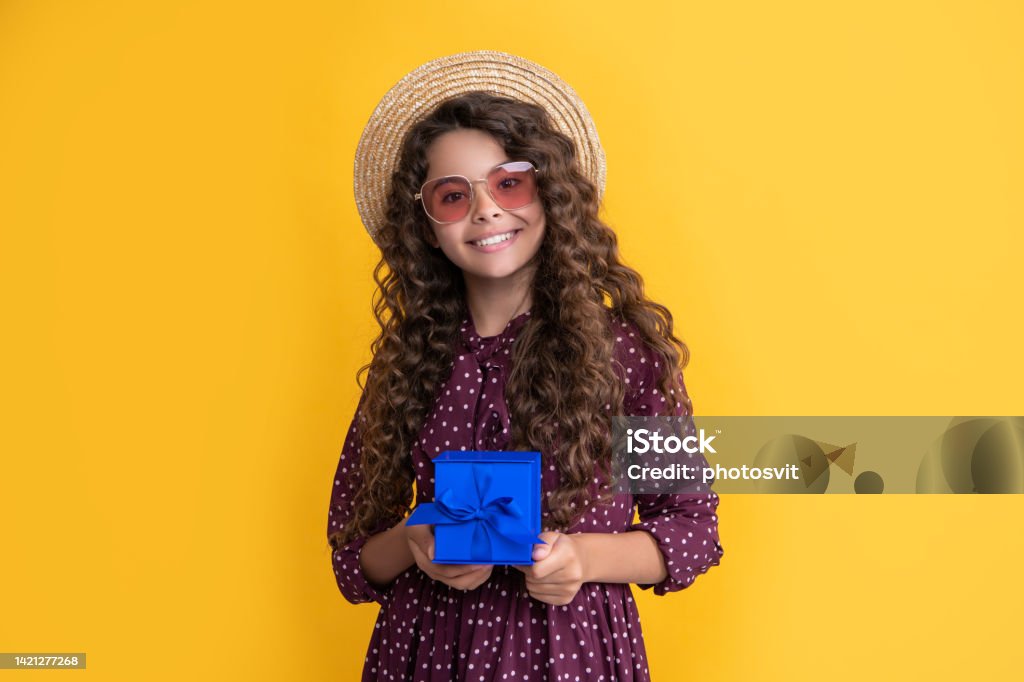 smiling girl with curly hair hold present box on yellow background smiling girl with curly hair hold present box on yellow background. Advertisement Stock Photo