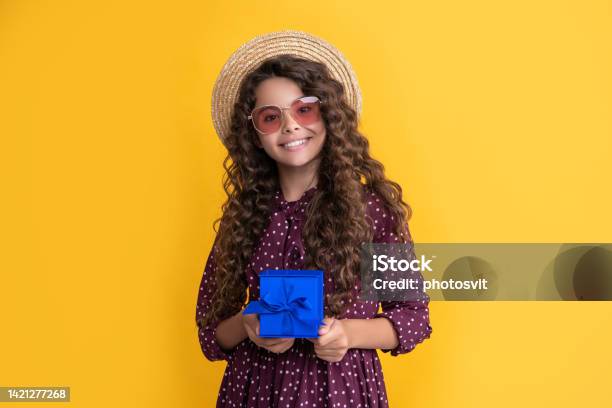Smiling Girl With Curly Hair Hold Present Box On Yellow Background Stock Photo - Download Image Now