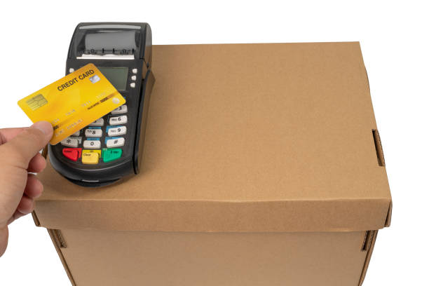 Man paying credit card and entering pin code on credit card swipe machine on package box on white back ground. Man paying credit card and entering pin code on credit card swipe machine on package box on white back ground. merchants gate stock pictures, royalty-free photos & images
