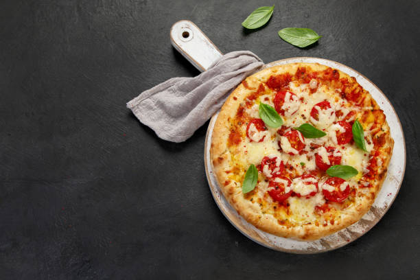 istock Freshly baked pizza on dark background. 1421281345