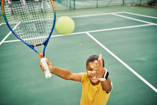Tennis girl throw ball to serve, hit and play sports match, fun game and competition on court playground. Youth, junior player and excited active kid with energy, racket and healthy fit development