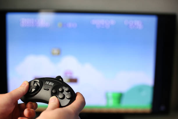 istock Plays a retro game on the TV while holding classic black joystick 1421287279