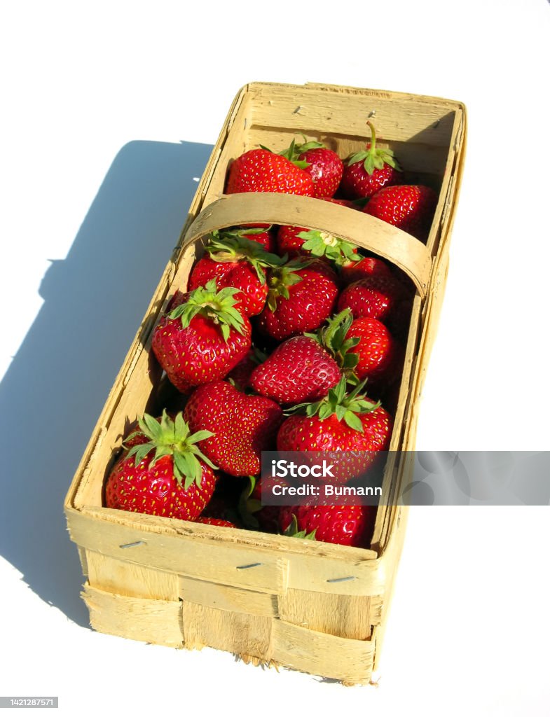 Fresh strawberries in a chip basket against a white background Basket Stock Photo