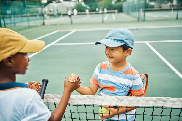 aperto de mão para jogos, competição e diversão na quadra ao ar livre do clube de esportes juvenis. jovens amigos da escola, meninos felizes e crianças sorrindo com boa esportividade, apoio e campeão vencedor - tennis child childhood sport - fotografias e filmes do acervo