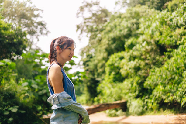 istock Serene woman standing in the forest 1421294180