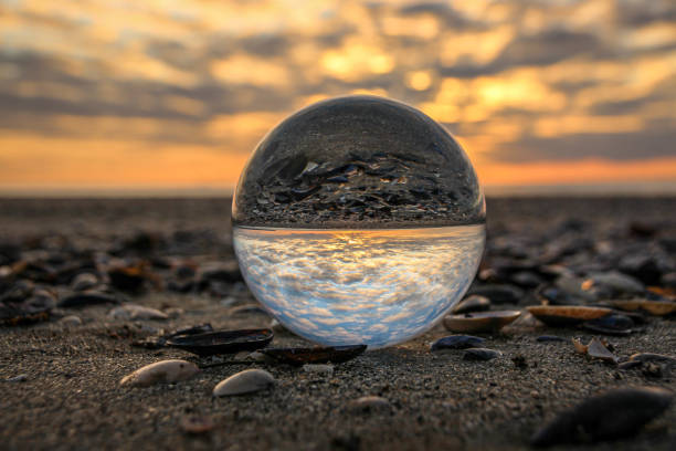 istock Sunset over the ocean with glass sphere 1421295029