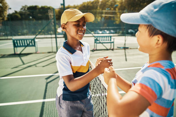 tênis crianças aperto de mão para jogo, competição e jogo divertido na quadra ao ar livre do clube de esportes ensolarado. jovens amigos da escola, meninos felizes e crianças sorrindo com boa esportividade, apoio e vitória vencedora - tennis child childhood sport - fotografias e filmes do acervo