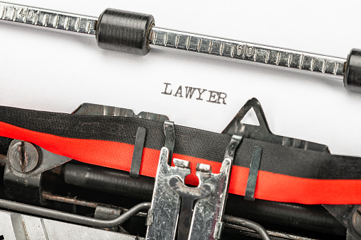Typewriter spells out LAWYER in black ink