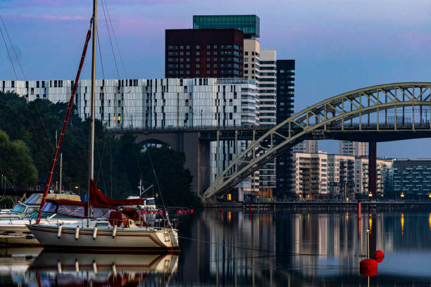 Stockholm, Sweden Aug 18, 2022 The Arsta Bridge at dawn and a sailboat in a marina.