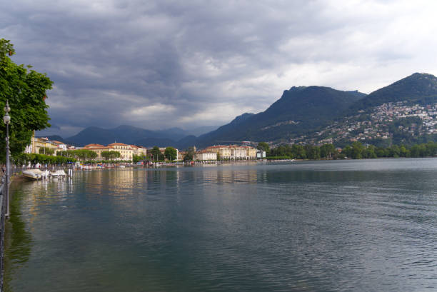 malowniczy widok na zatokę jeziora lugano, kanton ticino, z panoramą górską w tle w pochmurny letni dzień. - ticino canton mountain lake lugano lake zdjęcia i obrazy z banku zdjęć