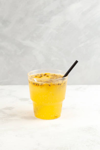 istock Yuzu and Passion fruit drink cocktail. Fruit lemonade in disposable plastic take away cup. Refreshing Iced drink 1421301221
