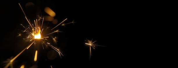 istock Burning sparkler macro isolated on a black background with free copy space for text. 1421302168