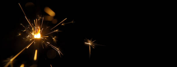 istock Burning sparkler macro isolated on a black background with free copy space for text. 1421302184