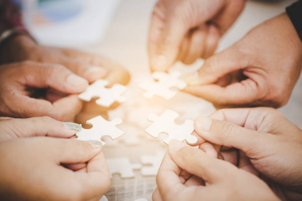 istock Hands holding piece of blank jigsaw puzzle for teamwork 1421303196