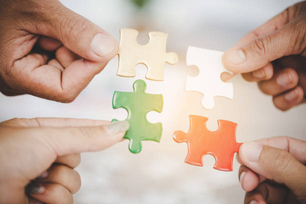 istock Hands holding piece of blank jigsaw puzzle for teamwork 1421304201
