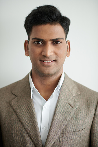 Portrait of smiling Indian entrepreneur in white shirt and jacket looking at camera