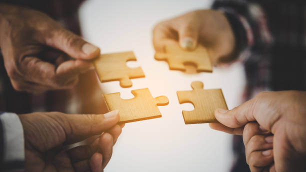 istock Hands holding piece of blank jigsaw puzzle for teamwork 1421305344