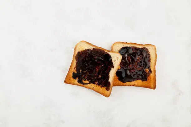 Photo of Two Hot toasts for breakfast, top view. Roasted Aussie savory toasts with vegemite spread. Vegemite is a very popular yeast based spread in Australia