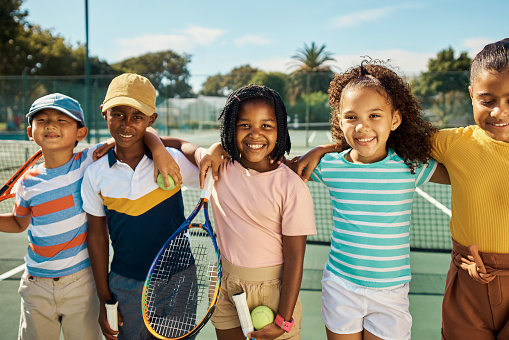 Children or tennis friends in happy sports portrait during their training practice in a game court. Diversity group of active, healthy and wellness kids playing fun, excited and sport match together