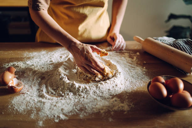 istock Anonymous Woman Mixing Eggs With Flour for Homemade Bread 1421310428