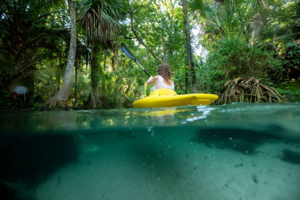 istock Female enjoying the tropical scene while outdoors on a kayak 1421310464