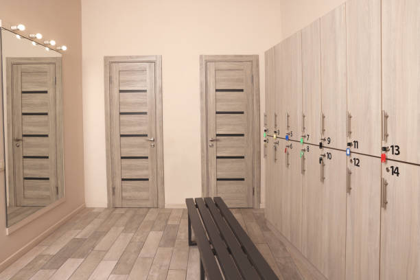 istock Wooden bench, mirror and lockers in changing room interior 1421310784