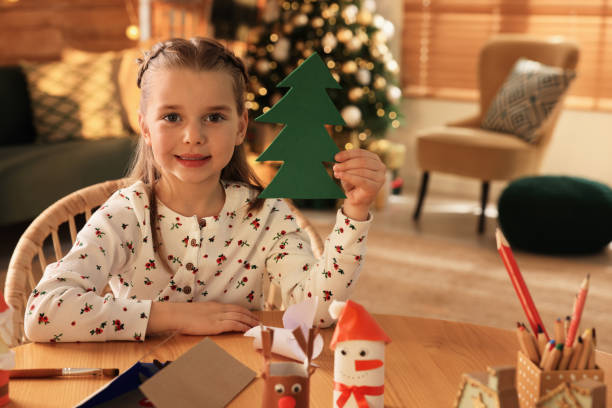 istock Cute child holding felt fir tree at home. Making Christmas decor 1421310797