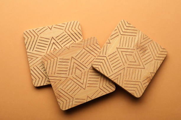 istock Stylish wooden cup coasters on orange background, flat lay 1421310879