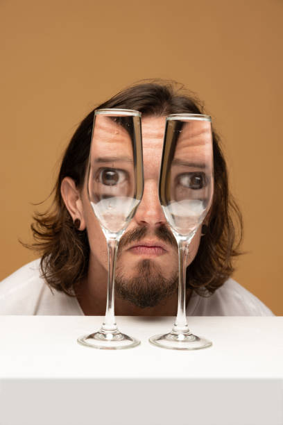 Surprise. Weird emotions, facial expression concept. Happy man's face through wine glasses. Object distortion, optical illusion. Minimalistic contemporary art. Poster