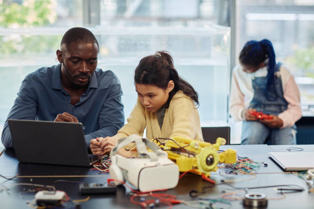 istock Male Teacher in Robotics Class with Young Student 1421313088