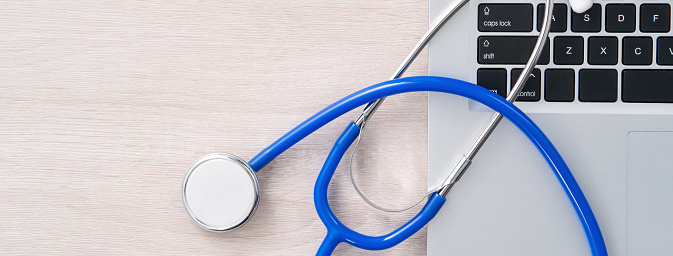 Doctor diagnoses design concept - stethoscope on computer keyboard with medical record clipboard on white working table.