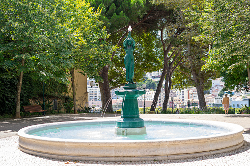 green statue and water fountain in the center of Jardim do Torel in Lisbon city