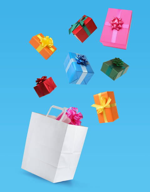 istock Many different gift boxes falling into paper shopping bag on light blue background 1421313779